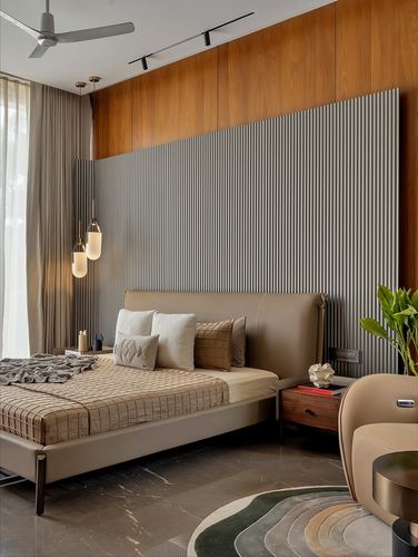 Bedroom with leather bed, fluted grey wall panel, wood cladding, and layered pendant lights
