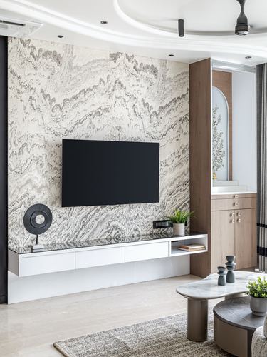 Living room with book-matched stone feature wall, floating console, and arched wood niche