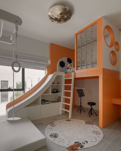 Child's bedroom with orange loft bed structure, slide, climbing net, and round space-themed rug