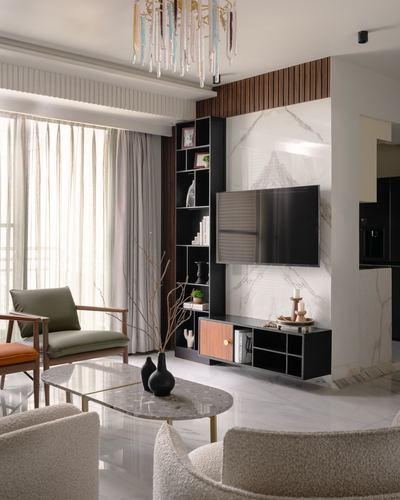 Living room with marble feature wall, floating black TV unit, and boucle armchairs around an oval marble coffee table