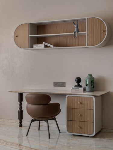 Study corner with rounded wall shelf, marble-top desk, and brown leather bolster chair