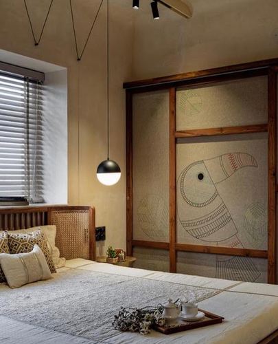 Bedroom with cane headboard, black pendant light, and wardrobe featuring hand-drawn toucan artwork on fabric panels.