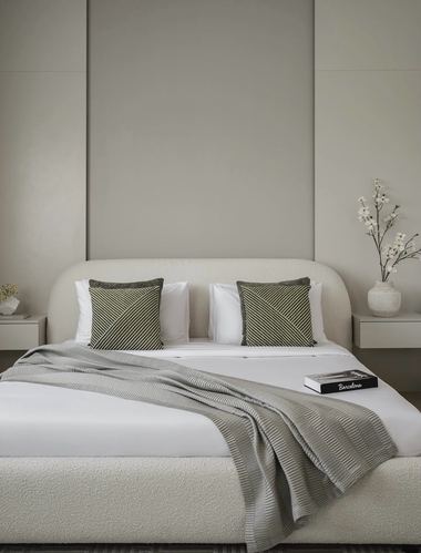 Neutral bedroom with boucle bed, striped olive cushions, and floating nightstands against paneled wall
