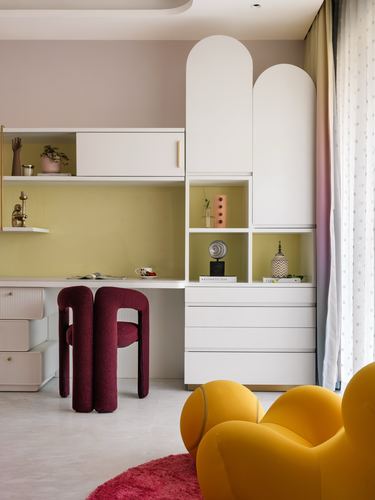 Study nook with arched white cabinetry, mustard backsplash, burgundy chairs, yellow curved sofa