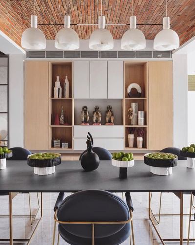 Dining room with brick vaulted ceiling, white pendant lights, black table and wood-white display cabinet