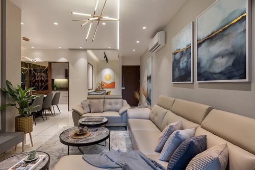 Muted beige living room with sectional sofa, layered artwork and sculptural pendant light