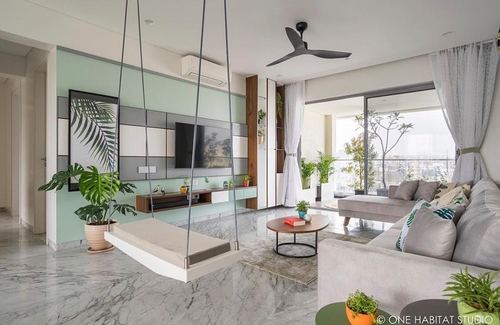 Living room with sage TV wall, hanging swing, marble floor and balcony view