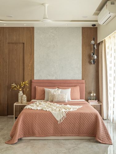 Bedroom with terracotta quilted headboard, wood-panelled wall, central stone strip, and marble flooring