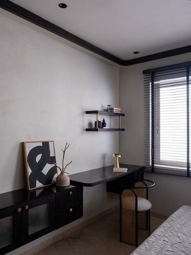 Minimalist study nook with black floating desk, wall shelf, cane chair, and window with wooden blinds