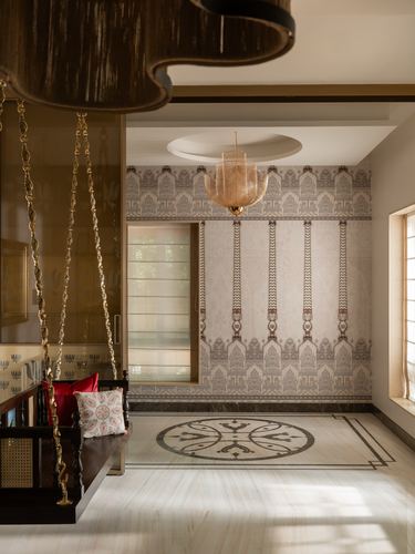 Entry foyer with wooden brass-chained swing, patterned wallpaper wall, and inlaid marble floor medallion.