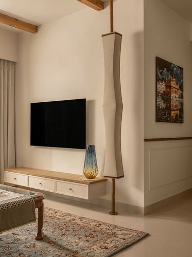 Living room with floating tv console, ribbed fabric floor lamp, and framed painting on wainscoted wall