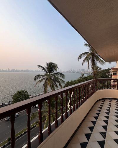 Balcony with turned wooden railing and diamond tile floor overlooking Marine Drive and the sea