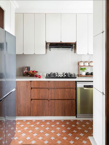 Kitchen with curved white cabinets, wood-grain lower units, and patterned terracotta floor tiles