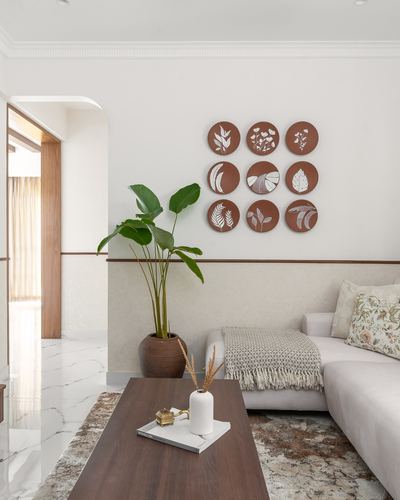Living room corner with terracotta botanical wall discs, wooden coffee table and marble floor