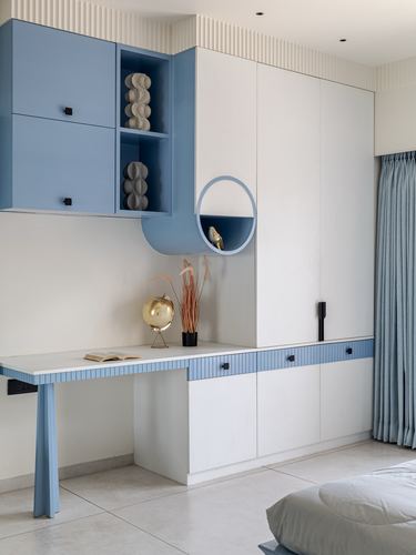 Blue and white built-in study desk and cabinets with a round niche shelf