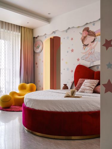 Round red velvet bed with bow headboard in whimsical star-themed girl's bedroom