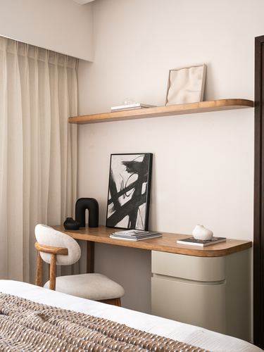 Bedroom desk nook with wood shelf, black abstract art, and sage cabinetry beside curtained window