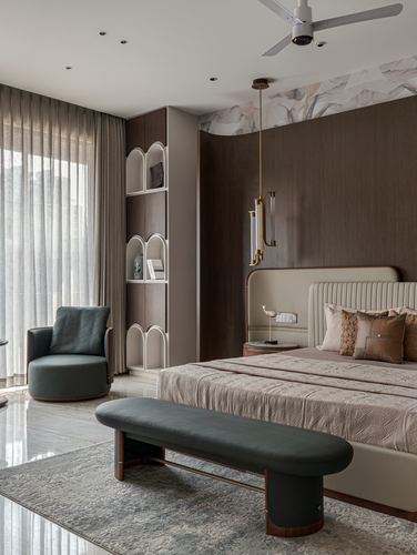 Bedroom with dark wood panelling, arched shelf, beige tufted bed and green bench