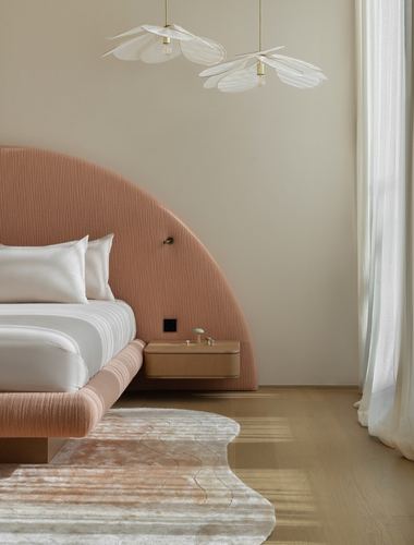 Bedroom with arched terracotta headboard, floating wood nightstand, and petal-shaped pendant lights