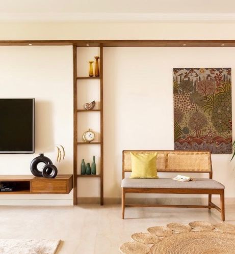 Living room with cane-back bench, TV console, ladder shelf and framed textile art