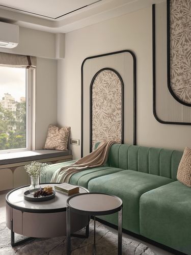 Sage green channel-tufted sofa against arched patterned wall panels with round marble coffee tables