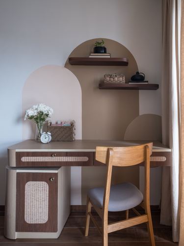 Wooden study desk with cane inlay drawers beneath arched blush and brown wall shapes and floating shelves