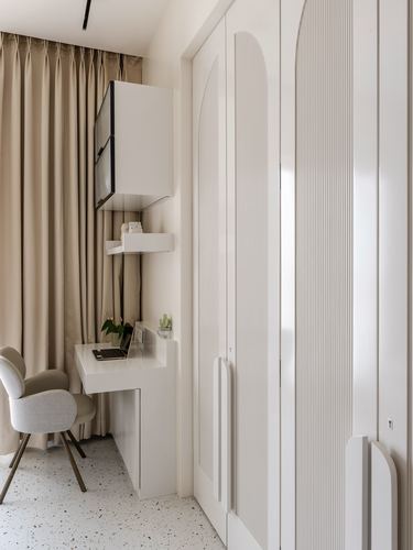Study nook with fluted white wardrobe, arched door, small desk, chair, and terrazzo floor