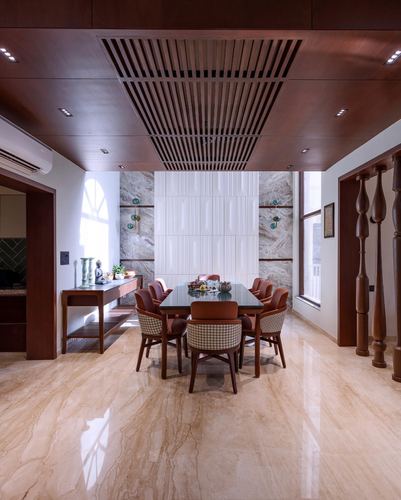 Dining room with glass table, leather chairs, marble wall panel, and slatted wood ceiling