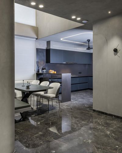 Dark stone-floored dining and kitchen area with blue cabinetry and curved archway