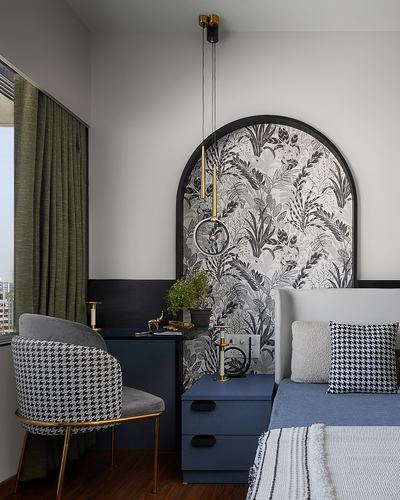 Bedroom corner with arched floral wallpaper panel, navy nightstand, and houndstooth armchair by window