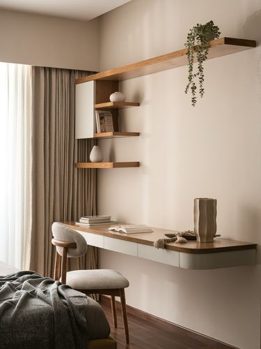 Floating wood desk and corner shelf with vases and trailing plant in a beige bedroom