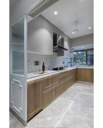 L-shaped modern kitchen with wood-toned base cabinets and white overhead units