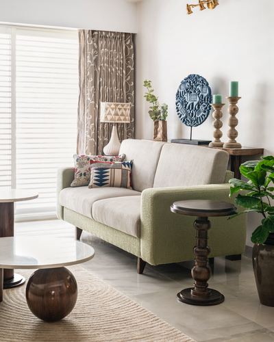 Beige and sage living room corner with turned wood side tables and patterned curtains