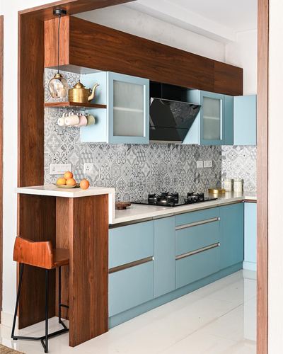 Blue modular kitchen with wood frame, patterned tile backsplash, and breakfast bar