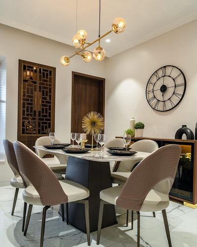 Dining room with marble table, black pedestal base, woven chairs and brass sputnik chandelier