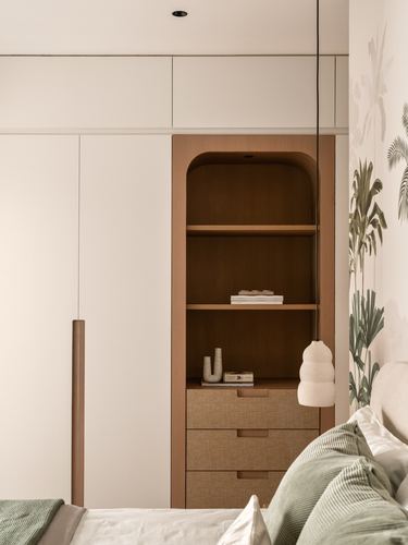 Arched wooden niche shelving beside bed with pendant light and leaf-print wallpaper