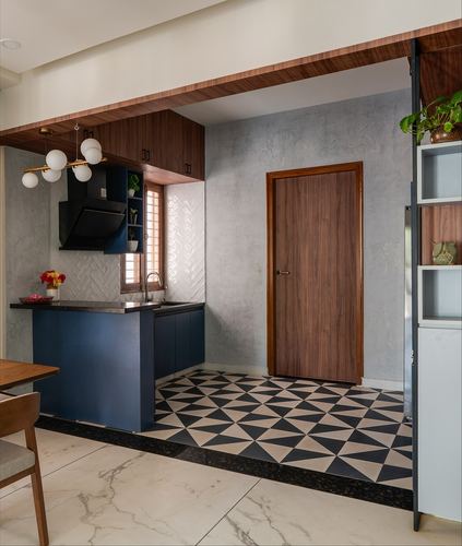 Compact kitchen with navy cabinetry, wood ceiling, and geometric black-white floor tile