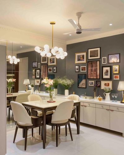 Dining room with gallery wall, brass chandelier, marble-top table and mirrored side wall