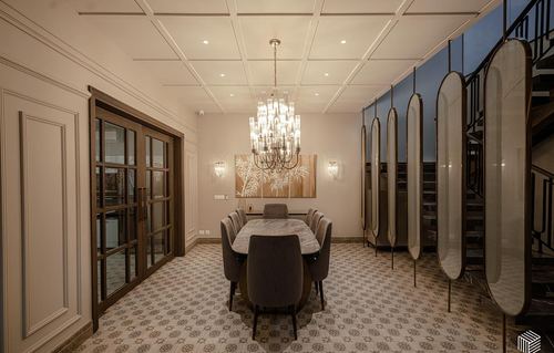 Formal dining room with marble table, tufted chairs, crystal chandelier and glass partition screen