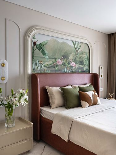 Bedroom with leather headboard, arched flamingo mural, moulded walls, and styled pillows