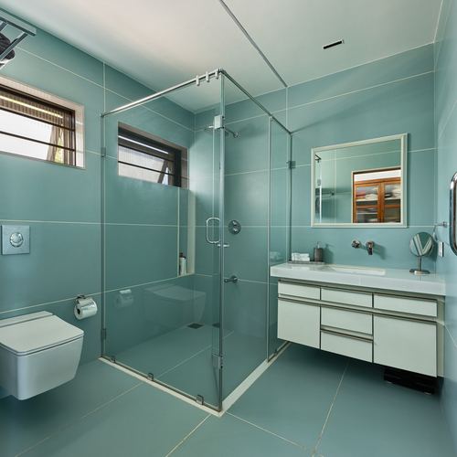 Seafoam green tiled bathroom with glass shower, floating vanity and wall-hung toilet