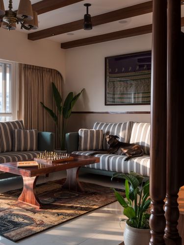 Living room with striped sofas, dog resting, chess set on wooden coffee table, framed saree art