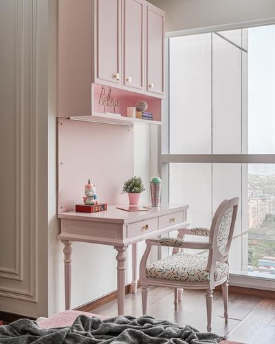 Pink study desk with cabriole chair beside a floor-to-ceiling window in Mumbai apartment