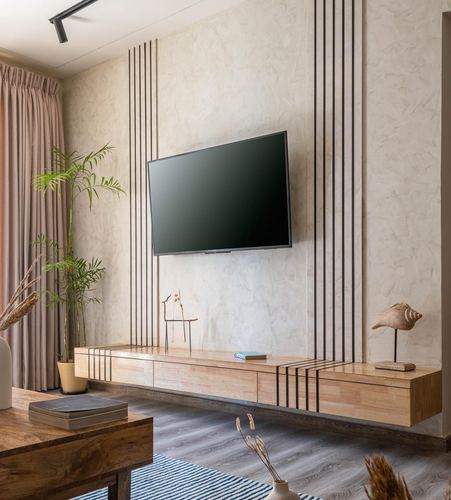 Living room with textured wall, mounted tv, floating wood console, and pink curtains