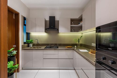 Modern muted-tone L-shaped kitchen with black chimney hood and under-cabinet lighting