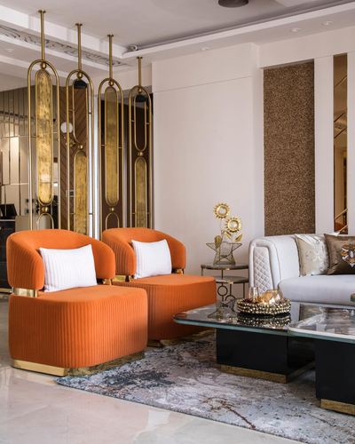 Living room with orange velvet chairs, brass screen divider, and black glass coffee table