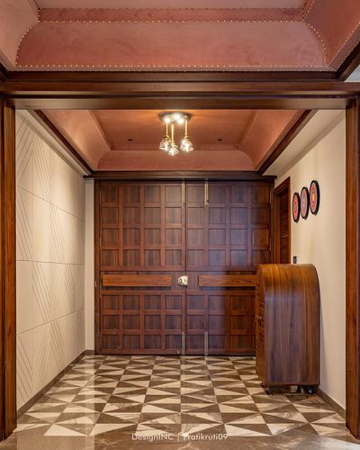 Grand foyer with wood-panelled double doors and geometric marble floor in Udaipur home