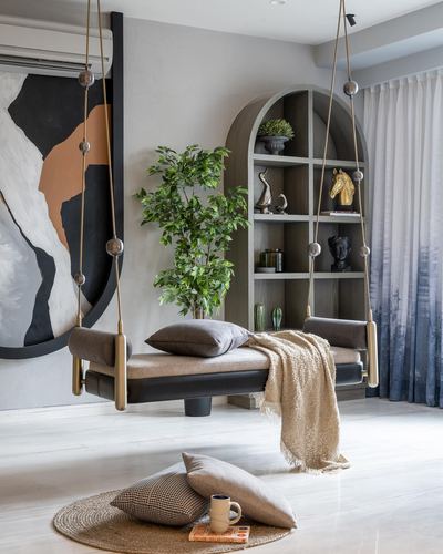 Hanging leather swing bench before arched bookshelf and abstract painting in styled living room