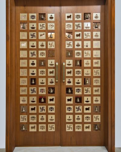 Wooden double door with rows of brass inlay tiles depicting religious motifs