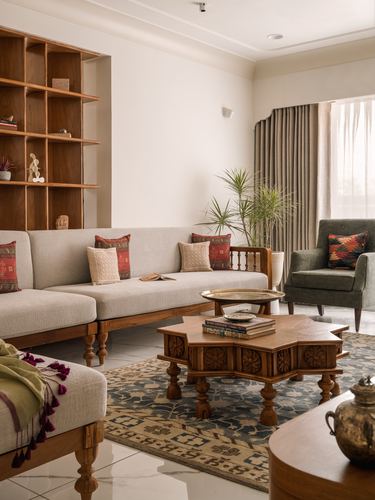 Living room with carved wooden coffee table, cane-backed sofa, wooden shelving and patterned rug